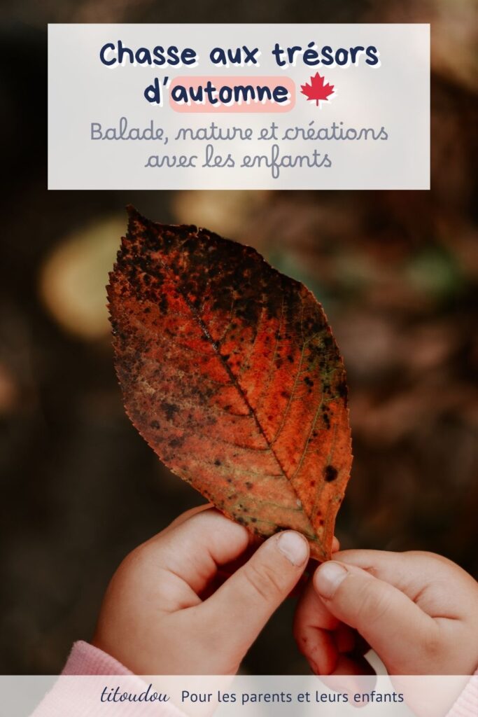 main d'un enfant qui tient une feuille d'arbre rouge à l'automne